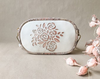 Perforierte Ledertasche in ivory und rosegold mit gelasertem Rosen-Motiv, Glitzer und floralem Muster, zur Bohohochzeit als Brautclutch