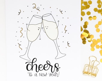 May include: A white card with a black line drawing of two champagne glasses clinking together. The glasses have faces and arms. The text "cheers to a new year!" is written in black cursive below the glasses.