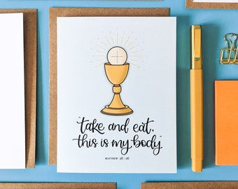 May include: A white card with a gold chalice and host, with the text "take and eat, this is my body" and "Matthew 26:26" underneath.
