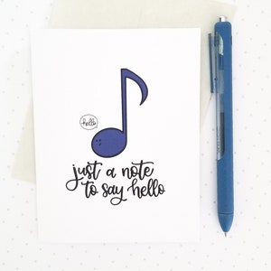 May include: A white card with a blue musical note and the text "just a note to say hello". The note has a small speech bubble with the word "hello" inside.