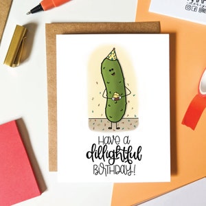 Cute pickle illustration holding a cupcake wearing a party hat saying have a dillightful birthday