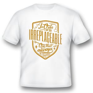 May include: White t-shirt with a gold graphic design that says "In Order to be Irreplaceable One Must Always Be Different".
