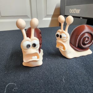 2 3d Printed multicolored cartooned snail character. Great for desktop