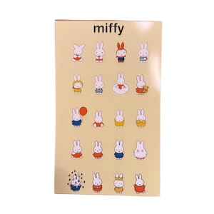 May include: A sticker sheet with multiple Miffy character designs. The stickers are on a light beige background, with the word "miffy" at the top. The stickers show Miffy in different outfits and poses, including holding a balloon and wearing a dress.