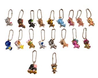 May include: A collection of small, colorful unicorn keychains with various designs and metallic accents. Each keychain features a different color scheme, including silver, gold, blue, pink, and black, and is attached to a metal chain.