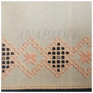Peut inclure: Gros plan sur un tissu beige avec une bordure décorative de broderie couleur pêche. La broderie présente un motif répétitif de carrés et d'étoiles.