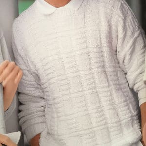 May include: A white knitted jumper with a textured pattern. The jumper has a round neckline and long sleeves.