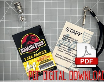 Könnte beinhalten: Zwei druckbare Jurassic Park-Ausweise. Die erste Karte ist ein schwarzer und gelber Jurassic Park Park Ranger-Ausweis mit einer roten Dinosauriersilhouette. Die zweite Karte ist ein weißer Mitarbeiter-Ausweis mit dem Text "STAFF" in Schwarz. Der Text "Employee ID: 8675309" ist auf der Karte gedruckt. Der Text "Department: Parks and Site: Isla Soma" ist auf der Karte gedruckt. Der Text "This card is Non-Transferable, the property of INGEN. Its use is governed by the INGEN Employee Card Holder Agreement. Report lost or stolen cards to the Security Office at extension 4-001" ist auf der Karte gedruckt. Der Text "Gen" ist auf beiden Karten gedruckt.