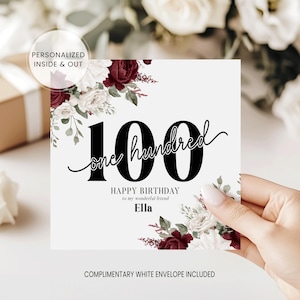 May include: A white birthday card with the number "100" in large black font, and the words "one hundred" in a script font. The card is decorated with burgundy and white floral arrangements. The text "HAPPY BIRTHDAY to my wonderful friend Ella" is also present.