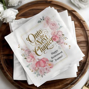 May include: White paper napkins with a gold frame and the text "Onto the Next Chapter" in gold script. The design features pink and white watercolor flowers, green leaves, and a pink pumpkin. The text "Happy Retirement Joanne!" is also included.