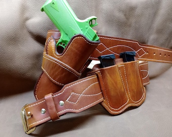 May include: A brown leather gun belt with a holster and magazine pouches. The holster holds a green toy gun. The belt has white stitching and a gold-colored buckle.