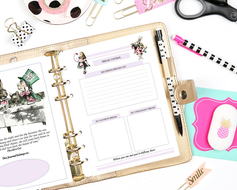 May include: A gold-colored planner with a white page open to a dream journal spread. The page features a whimsical illustration of Alice in Wonderland characters, including the Mad Hatter and the Cheshire Cat. The page is divided into sections for recording dreams, favorite dreams, and unpleasant dreams. The text "DREAM CONTROL" is printed at the top of the page.