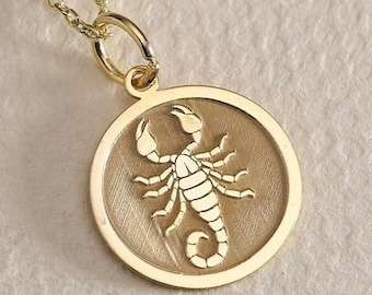 May include: Gold necklace with a round pendant featuring a detailed scorpion design.