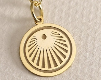 May include: A gold necklace with a round pendant featuring a sunburst design.
