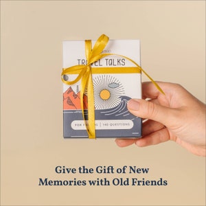 May include: A blue box wrapped in a yellow ribbon with the text "Travel Talks" and "For Friends | 140 Questions". The box is being held by a hand. The text "Give the Gift of New Memories with Old Friends" is below the box.
