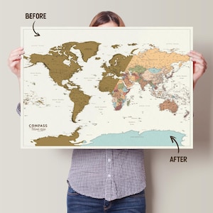 May include: A world map with a scratch-off surface, showing the world before and after scratching. The map features a beige background with gold and colorful details. The text "COMPASS travel map" is visible on the map.