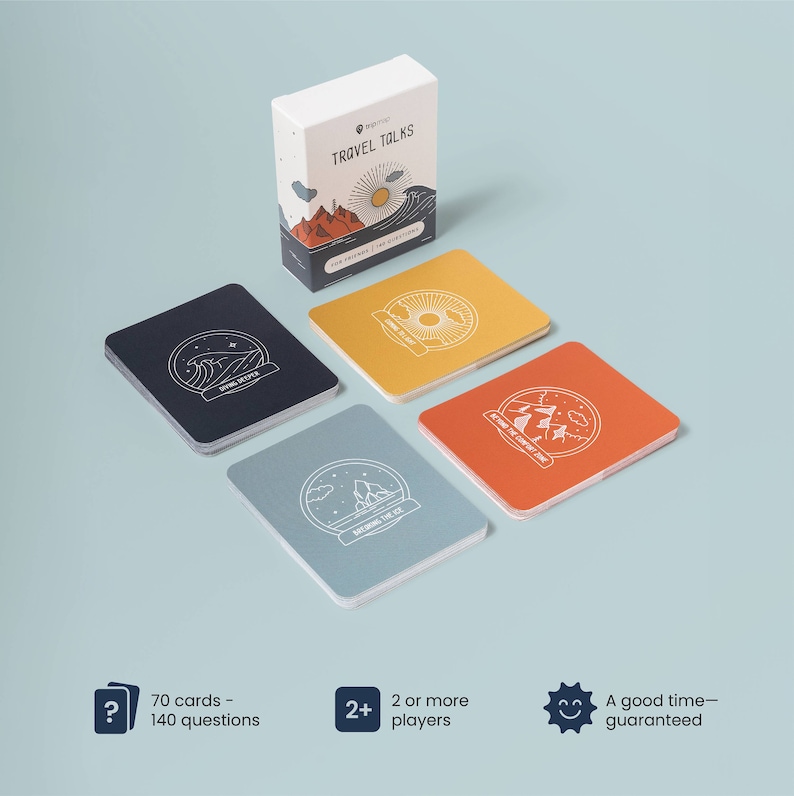 May include: A box of Travel Talks conversation starter cards with four cards laid out on a blue background. The box is white with a blue and orange illustration of mountains, a sun, and waves. The cards are blue, orange, yellow, and black with white illustrations of a wave, mountains, a sun, and an iceberg.