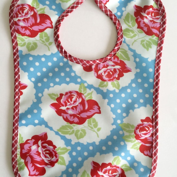 Bavoir pour bébé, en tissu enduit, bleu azur, motif  imprimé roses rouge sur bleu a pois, style retro