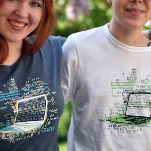 Könnte beinhalten: Zwei Personen tragen T-Shirts mit einem grafischen Design eines Laptops, das aus Code besteht. Das Design ist in Grün-, Blau- und Weißtönen gehalten. Der Text auf den Shirts lautet "<p>" und "<p>"