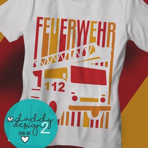 Może przedstawiać: Biała koszulka z czerwono-żółtym nadrukiem przedstawiającym wóz strażacki z napisem "FEUERWEHR" i numerem "112".