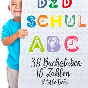 May include: A child holds a poster with colorful letters spelling "D2D SCHUL ABC" with illustrations of a magnifying glass, clock, pencil, compass, globe, and alarm clock. The poster also includes the text "38 Buchstaben 10 Zahlen & tolle Deko".