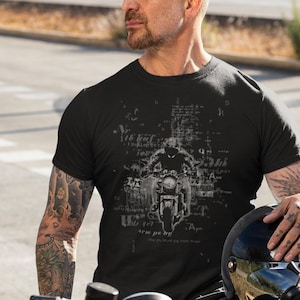 May include: Black t-shirt with a graphic print of a motorcycle and text that reads "N 11th kat G de gri b liu od mar A 2kai phu Mantoм Хале хом A S".
