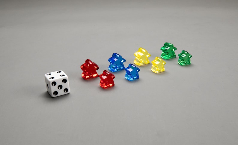 Puede incluir: Un dado blanco con puntos negros y siete casas de pl&aacute;stico de colores en rojo, azul, amarillo y verde.