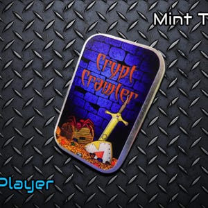 May include: Rectangular mint tin with the text "Crypt Crawler" on a blue brick background. A yellow sword and treasure chest are also featured. The text "Mint Tin!" and "1 Player" are also visible.