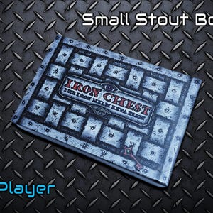 May include: A rectangular box with the text "Small Stout Box!" and "Iron Chest The Iron Helm Expansion" in red and white. The box has a blue and white pattern and the text "1 Player" in blue.