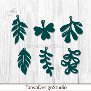 May include: Six dark teal leaf-shaped cutouts with small holes for hanging. The leaves vary in shape, including a three-leaf clover, fern-like designs, and other stylized foliage. The text "TanyaDesignStudio" and "Digital Template" are at the bottom.