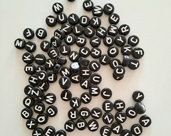 Alphabet-Buchstabenperlen, schwarze Perlen, weiße Buchstaben, Set mit +- 100 Stück pro Packung