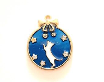 1 white cat medallion charm with stars, blue background, golden outlines, enameled colors