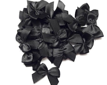 10 small black satin bows, +- 3 x 2.5 cm