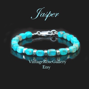 May include: A bracelet featuring turquoise-colored jasper beads with brown veining, interspersed with small silver-toned metallic spacers. The piece includes a silver-toned lobster clasp. Text on the image reads Jasper, VintageRoseGallery Etsy, and www.etsy.com/shop/VintageRoseGallery.