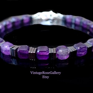 May include: A bracelet featuring purple gemstones and silver-coloured metal. The amethyst stones are square-cut. The bracelet is set against a black background. The Etsy shop name "VintageRoseGallery" is visible.