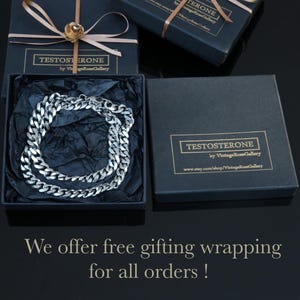 May include: A silver-toned curb chain necklace rests inside a black square gift box lined with black tissue paper. Two additional black gift boxes are present, each tied with a light brown ribbon and featuring a label that reads TESTOSTERONE by VintageRoseGallery.