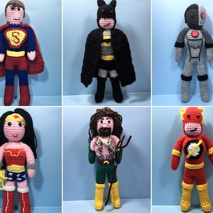 Op de afbeelding: Gehaakte superheldenpoppen, waaronder Superman, Batman, Cyborg, Wonder Woman, Aquaman en The Flash. De poppen staan ​​allemaal en hebben gedetailleerde kenmerken, waaronder gezichtsuitdrukkingen en kostuums.
