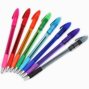 Puede incluir: Un juego de ocho bolígrafos con cuerpos transparentes y tinta de colores. Los bolígrafos están dispuestos en un patrón de arcoíris, con tinta roja, naranja, amarilla, verde, azul, morada y negra.