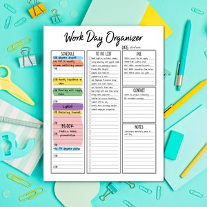 May include: A white Work Day Organizer sheet with a schedule, to-do list, due dates, contact, and notes sections. The sheet is surrounded by pens, paperclips, and other office supplies on a teal surface. The date is 2/26/2021.
