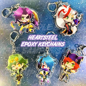 May include: A selection of Heartsteel epoxy keychains, each with a silver keyring and a unique anime-style character design. The keychains showcase characters with vibrant hair and outfits. The text "HEARTSTEEL EPOXY KEYCHAINS" is displayed on a purple banner.