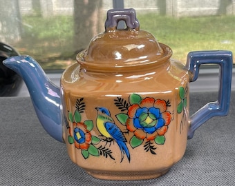 Zabytkowy czajniczek w stylu art déco z motywem ptaka, malowany ręcznie w kwiaty w kolorze pomarańczowo-niebieskim, z lat 50. XX wieku w Japonii, z mieniącą się brzoskwinią