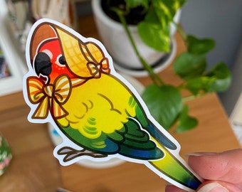 May include: A yellow and green parakeet wearing a yellow and white sunhat with a yellow and orange bow. The parakeet is a sticker with a white background.