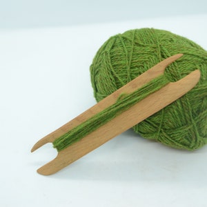 May include: A ball of green yarn with a wooden yarn needle.
