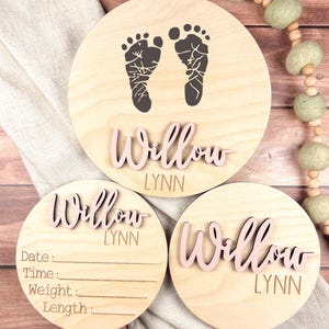 May include: Three wooden baby announcement plaques with the name Willow Lynn. The top plaque has a footprint design. The middle plaque has a blank space for writing the date, time, weight, and length. The bottom plaque has the name Willow Lynn.