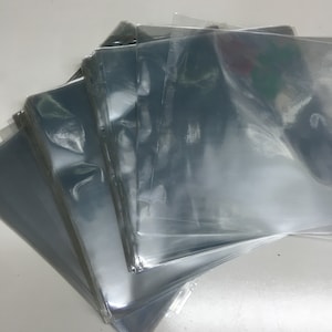 May include: A stack of clear plastic sleeves for protecting documents or photographs.
