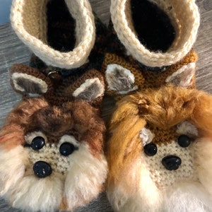 Peut inclure: Une paire de pantoufles en tricot marron et beige avec des visages d'animaux en fourrure marron et beige. Les pantoufles ont des yeux en boutons noirs et des nez noirs.