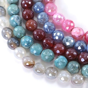 May include: Close-up of faceted gemstone beads in various colors, including pink, blue, brown, and teal. The beads are strung together, creating a textured and colorful display. The beads are likely used for jewelry making.