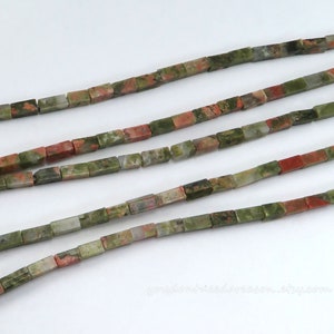 May include: A strand of green, red, and white square-shaped beads. The beads are made of a natural stone with a mottled pattern.
