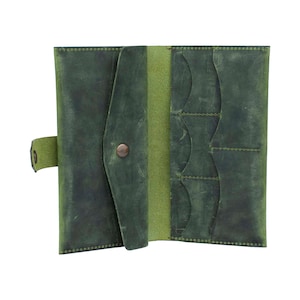 May include: Open, green leather wallet with multiple card slots and a button closure. The wallet has a distressed finish, giving it a vintage look. The interior is a lighter shade of green.