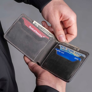 May include: A brown leather wallet with a billfold, a Bank of America credit card, a New York State debit card, and a PayPal Cash card.